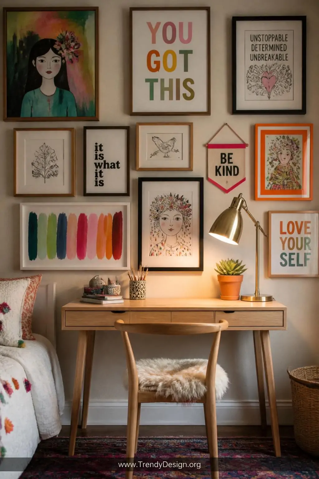 Vibrant gallery wall filled with colorful framed art prints, hand-drawn sketches and motivational typography above a slim natural wood writing desk holding a brass desk lamp and a single terracotta succulent, kids bedroom homework nook, bohemian eclectic style, warm focused lamplight against the richly layered wall, medium shot centered on the desk and gallery wall pairing, photorealistic interior design.